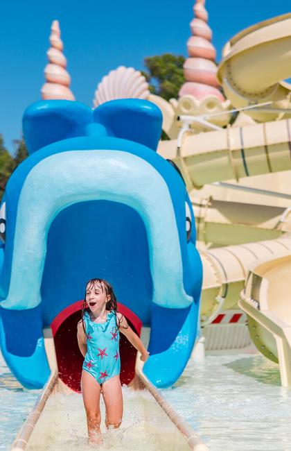 Kinder haben Spaß in einem Wasserpark mit Rutschen.