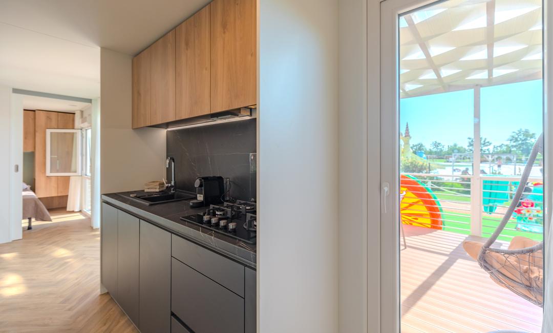 Modern kitchen with bright terrace and outdoor view.