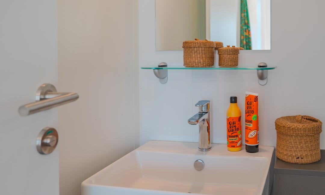 Bathroom with sink, mirror, and hair products.